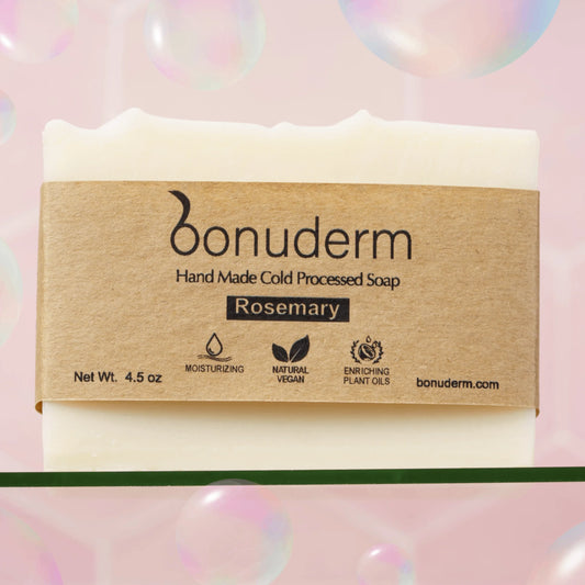 Rosemary bar soap with 'bonuderm' label on a pink background with bubbles.