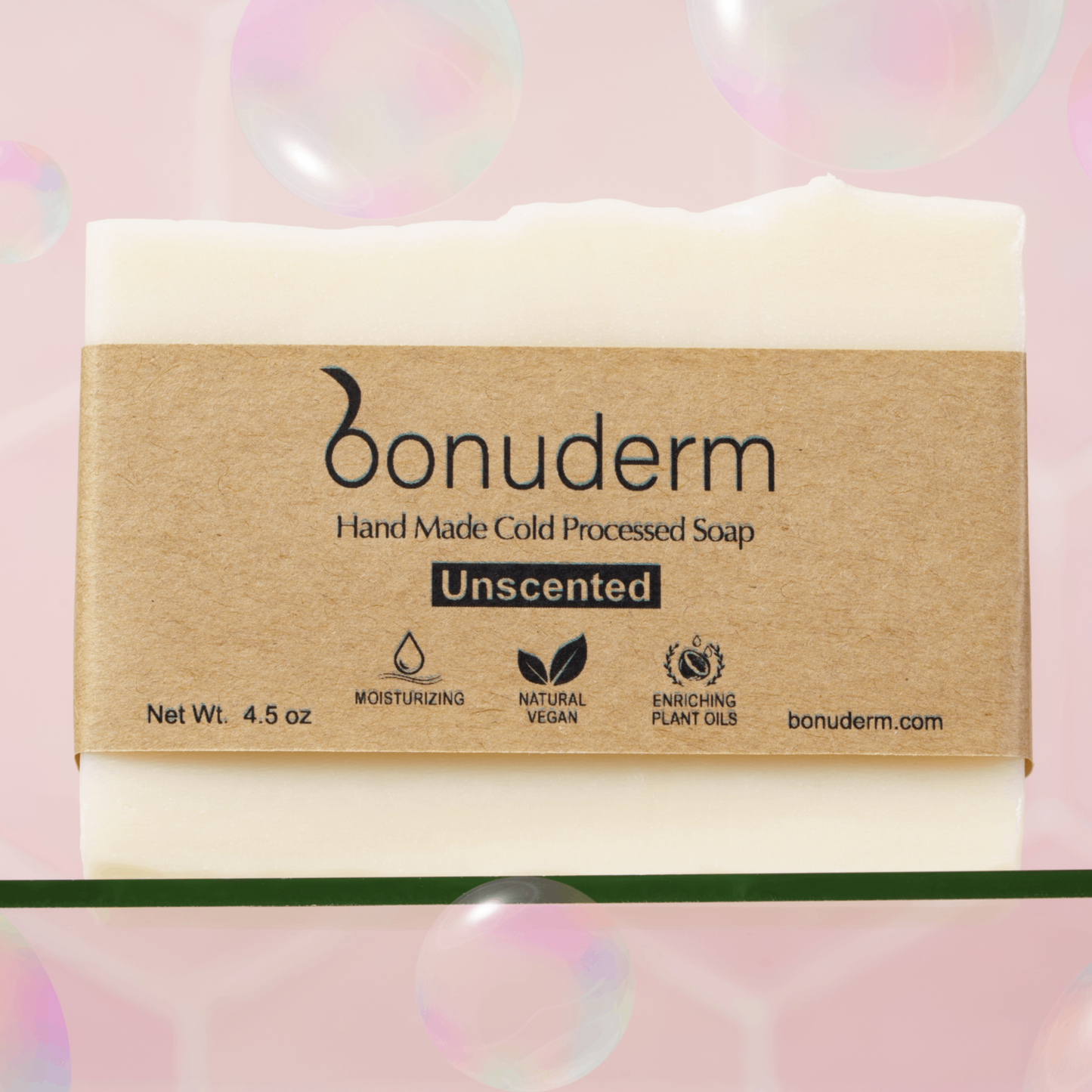 Handmade cold-processed moisturizing soap bar with 'bonuderm' label on a pink background