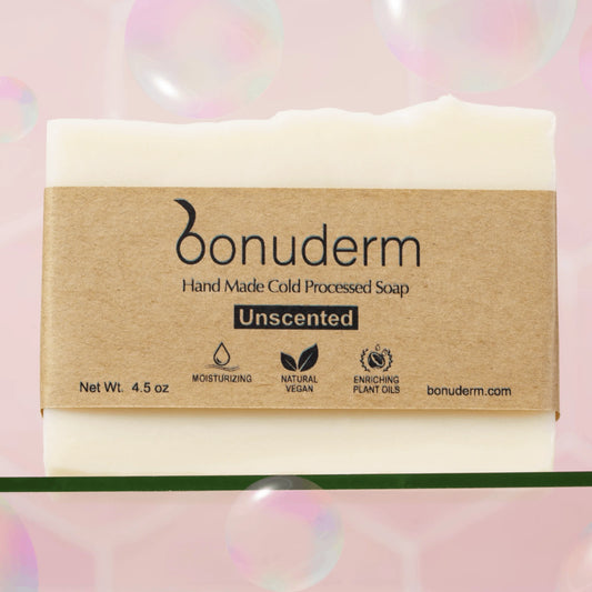 Handmade cold-processed moisturizing soap bar with 'bonuderm' label on a pink background