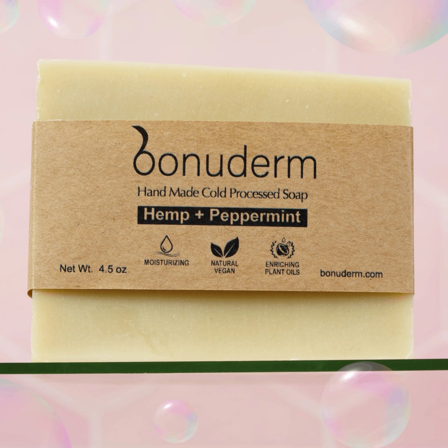 Peppermint bar soap with 'bonuderm' label on a pink background with bubbles with icons indicating moisturizing, vegan, and natural.