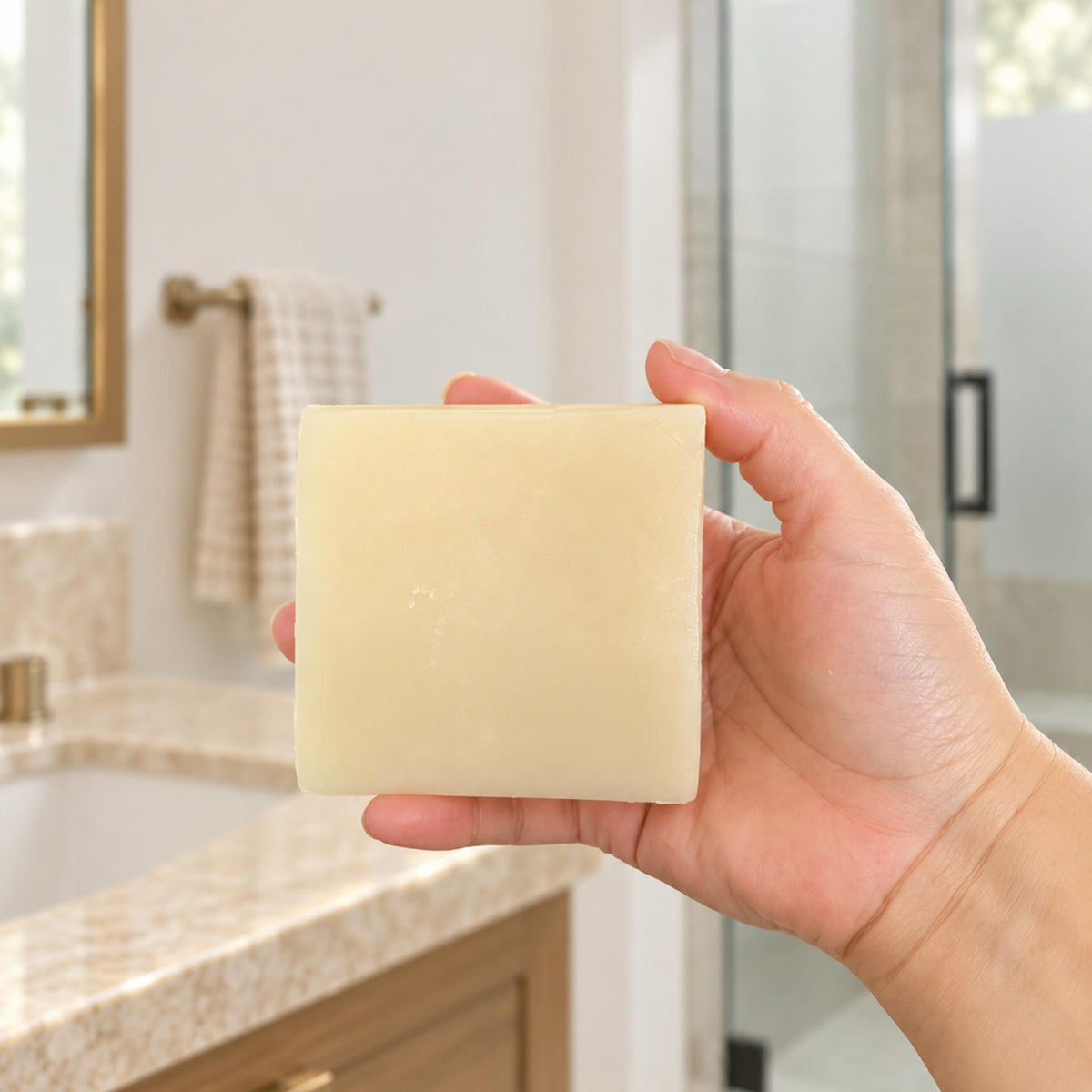EcoFriendly solid Shampoo bar hold by a hand in a bathroom 