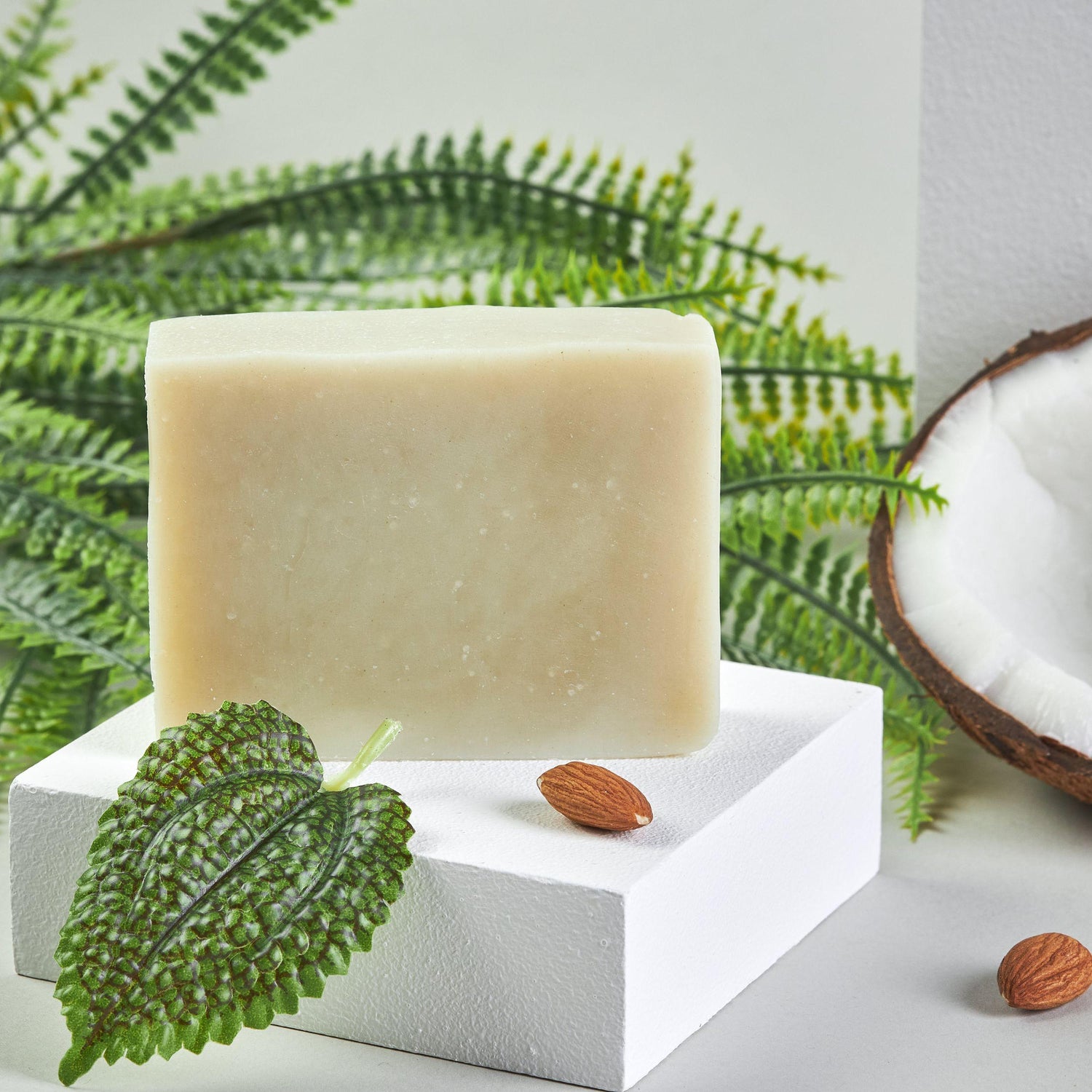 Bonuderm Peppermint Bar Soap next to raw peppermint leaves and coconut pieces