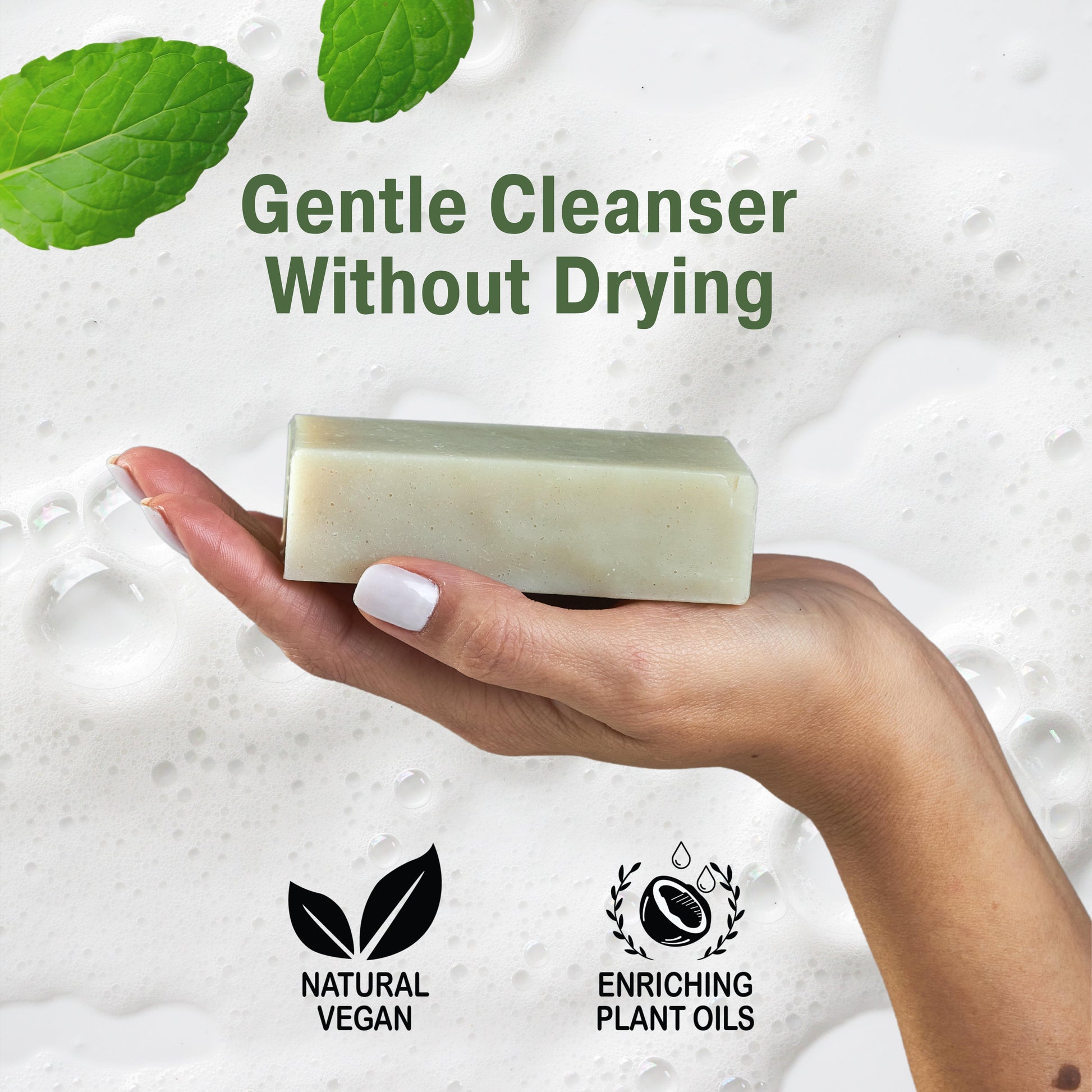 Hand holding a patchouli bar soap with green leaves and text about gentle cleanser and plant oils.