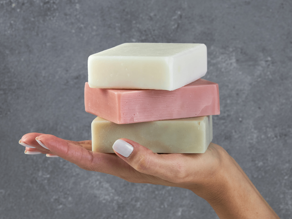 Plastic-free bar soaps held in hand, natural bar soaps for zero-waste personal care.