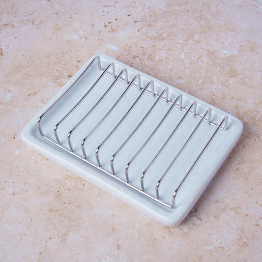 soap dish with metal bars on a beige surface
