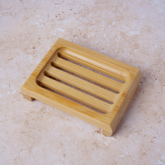 Wooden soap dish on a beige marble surface